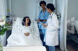 Female doctors interacting with female patient in the ward