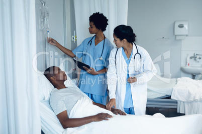 Female doctors adjusting iv drip in the ward at hospital