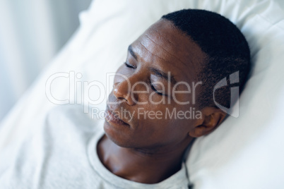 Male patient sleeping on bed in the ward