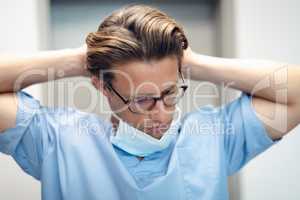 Male doctor removing surgical mask in the ward