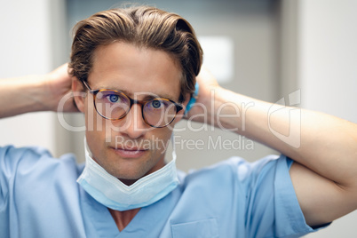 Male doctor removing surgical mask in the ward at hospital