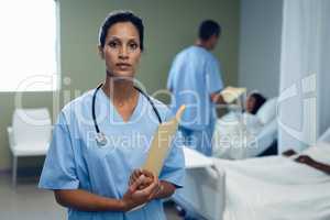 Female doctor standing with file in the ward at hospital