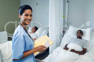 Female doctor looking at medical report in the ward at hospital