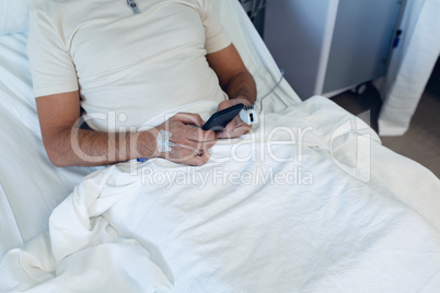 Male patient using mobile phone in the ward at hospital