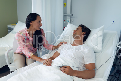 Woman consoling male patient in the ward