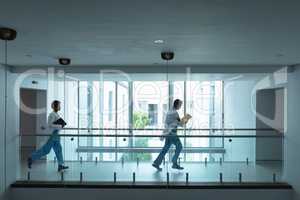 Female and male doctors running in the corridor at hospital