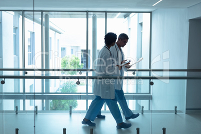 Male and female doctors interacting with each other in the corridor