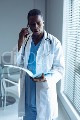 Male doctor talking on mobile phone in hospital