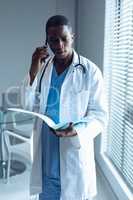 Male doctor talking on mobile phone in hospital