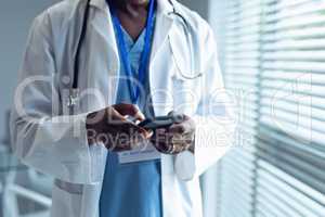 Male doctor using mobile phone in hospital