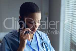 Female doctor talking on mobile phone in hospital