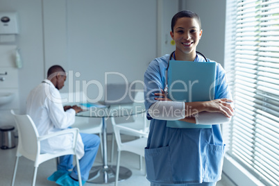 Female doctor holding file and smiling in the hospital Female doctor holding file and smiling in the hospital