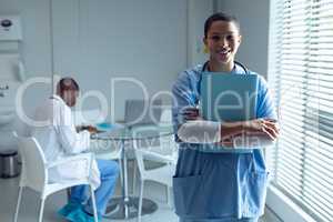 Female doctor holding file and smiling in the hospital