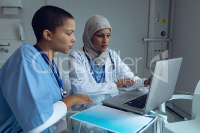 Female doctors using laptop in hospital