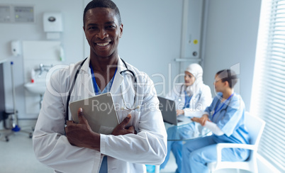 Male doctor standing with digital tablet in hospital