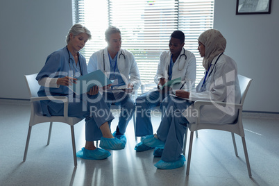 Medical teams discussing over file in hospital