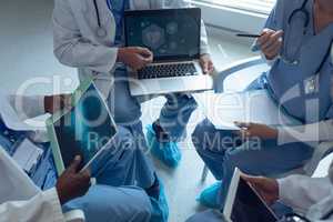 Medical teams discussing over laptop in hospital