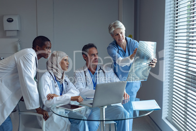 Medical team discussing over x-ray report in hospital