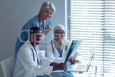 Happy medical team sitting on chair at hospital