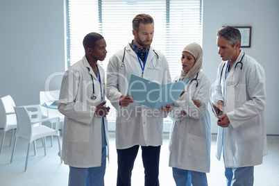 Medical team discussing over medical file at hospital