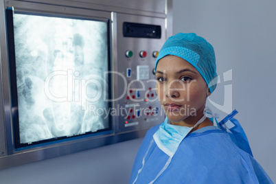 Female surgeon standing near x-ray light box at hospital