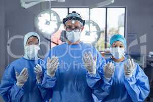 Surgeons gesturing while standing in operating room at hospital