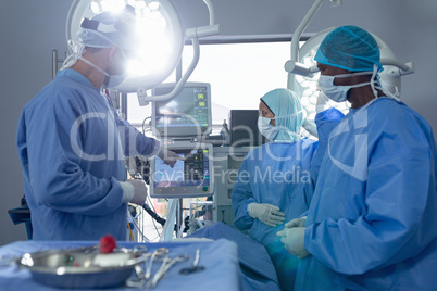 Surgeons discussing over medical monitor in operation theater at hospital