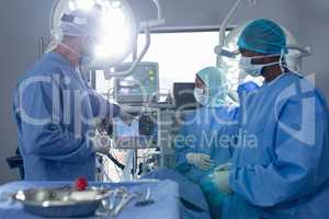 Surgeons discussing over medical monitor in operation theater at hospital