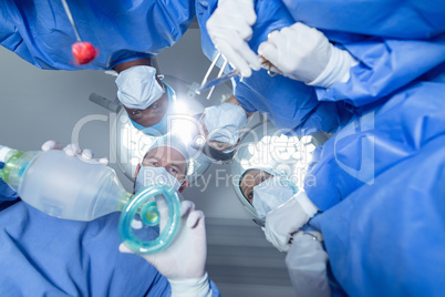 Surgeons standing with oxygen mask in operation theater at hospital