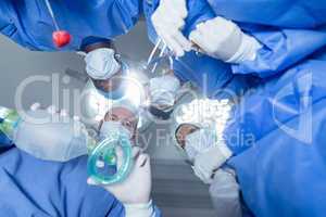 Surgeons standing with oxygen mask in operation theater at hospital