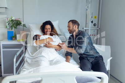 Couple holding their newborn baby in the ward