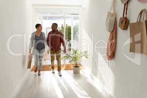 Couple entering hand in hand their home