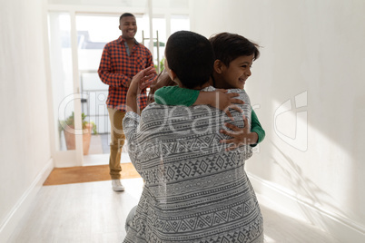 Mother embracing her son near doorway