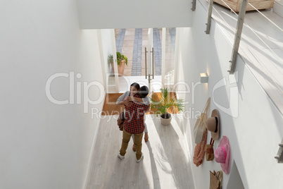Couple embracing each other near doorway at home