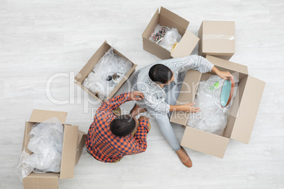 Couple unpacking cardboard boxes in living room