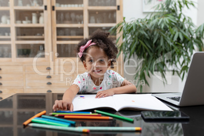 Girl doing her homework on table at home