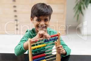 Boy playing with abacus on a table at home