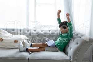 Boy playing games on digital tablet in living room at home