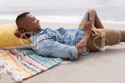Man using mobile phone while relaxing at beach