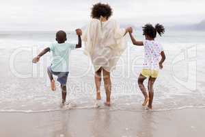 Mother and children playing together on the beach