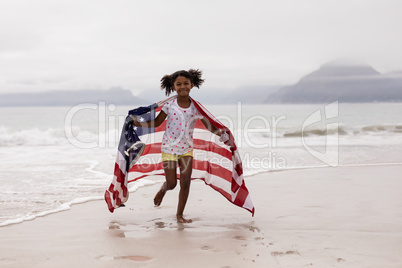 Girl running with American flag on the beach