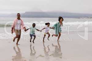 Family walking together hand in hand on the beach