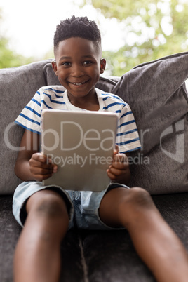 Boy using digital tablet in living room at home