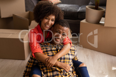 Happy couple sitting together in living room at home