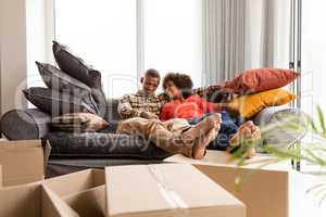 Couple sitting together on a sofa in living room at home