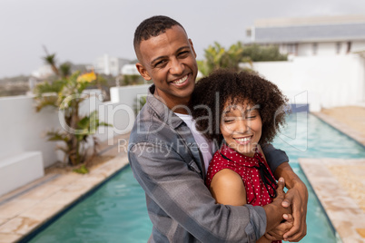 Couple embracing each other near swimming pool at home