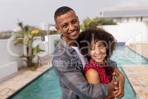 Couple embracing each other near swimming pool at home