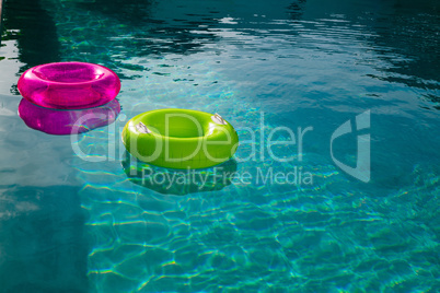 Inflatable tubes floating in a swimming pool in backyard