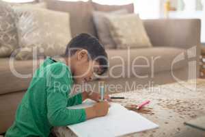 Boy drawing a sketch on book at home