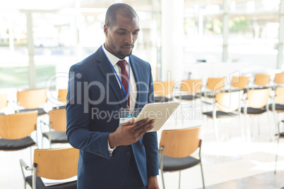 African-american businessman standing in conference room watching tablet